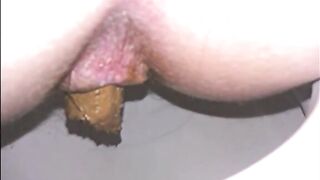 Woman shitting a long turd very slowly in the toilet