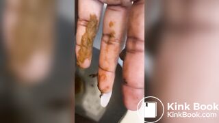 Ebony lady pushing pebbles into the toilet