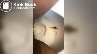 Ebony lady pushing pebbles into the toilet