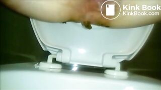 Woman shitting a long turd in the toilet