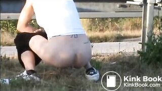 Girl shitting outdoor close to the road