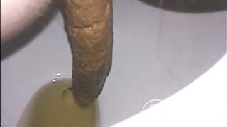 Woman shitting a long turd very slowly in the toilet