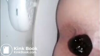 Woman shitting in the toilet closeup