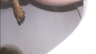 Woman shitting a long turd very slowly in the toilet