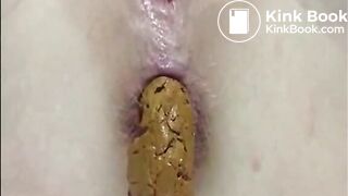 Shaved girl shitting closeup and fingering her pussy