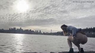 girl shitting in a lake shore