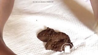 sexy brunette on her back pushes out a turd for you