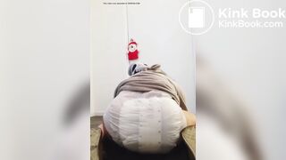 Girl sits and squishes in her poopy diaper