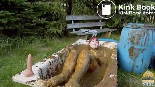 Busty babe masturbating in a bathtub full with cow shit