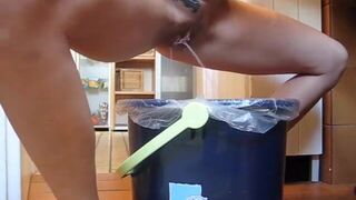 German lady defecates in a trash can..