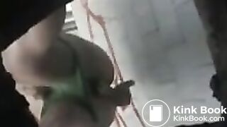 Girl in green bikini takes a dump in a public toilet.